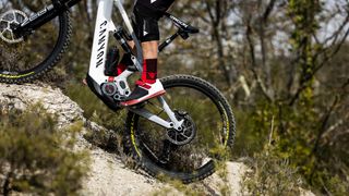 Rider climbing on rocky terrain on the Canyon Strive:ON