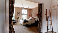 Bedroom with four posted bed, polka dot print curtains, woven carpet and ladder