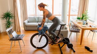 Woman riding turbo trainer at home