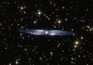 The icy blue, symmetrical wings of a planetary nebula called Hen 2-437 are captured in this photo from the NASA/ESA Hubble Telescope. Hen 2-437 is a bipolar nebula, which means the material ejected by the dying star stretches out into space in two directi