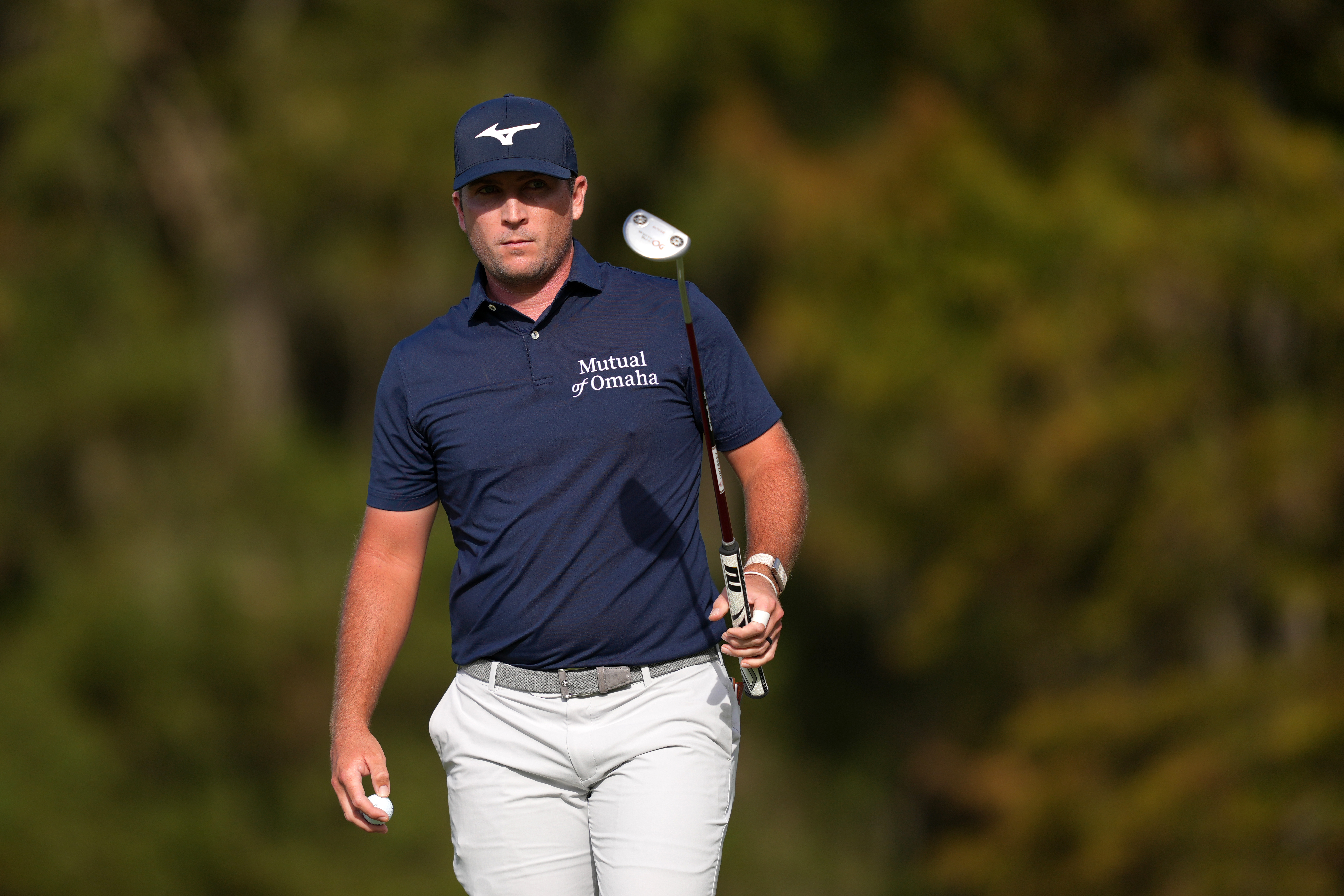 Steven Fisk walks off the green holding a putter