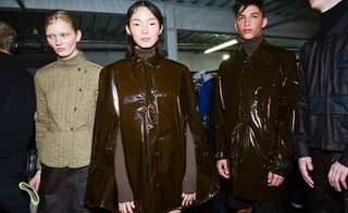 Three models - one with a beige padded hunting jacket, and two with brown waterproof coats