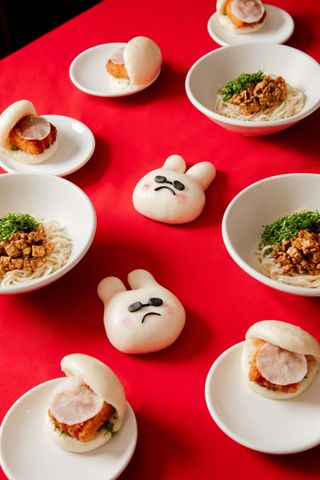 table at bao London with red tablecloth bunny-shaped bao buns and plates of noodles