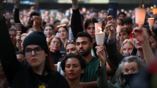 Supporters hold candles during a vigil at Town Hall in Sydney