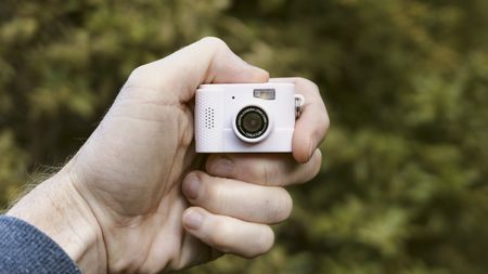 Miniature pink keychain camera, the 'Photo Creator Mini Digital Camera series 3', in user's hand