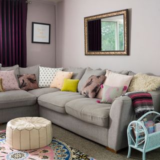 pink wall living room with sofa and carpet flooring