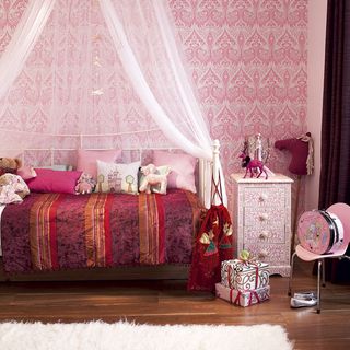 children's bedroom with pink wallpaper and wooden flooring
