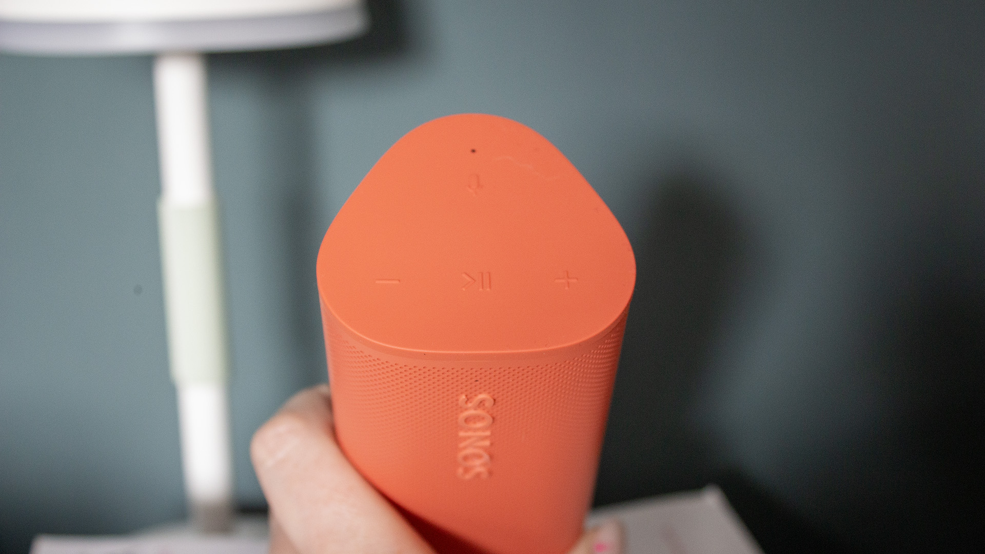the top of a red sonos roam 2 speaker held in a hand