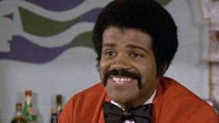 Ted Lange smiling in a bow tie and red jacket on The Love Boat