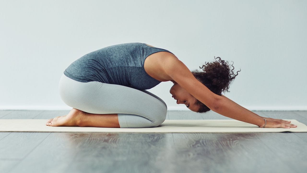 woman doing yoga childs pose for bedtime yoga