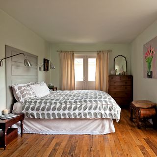 bedroom with wooden floor and white wall and grey headboard