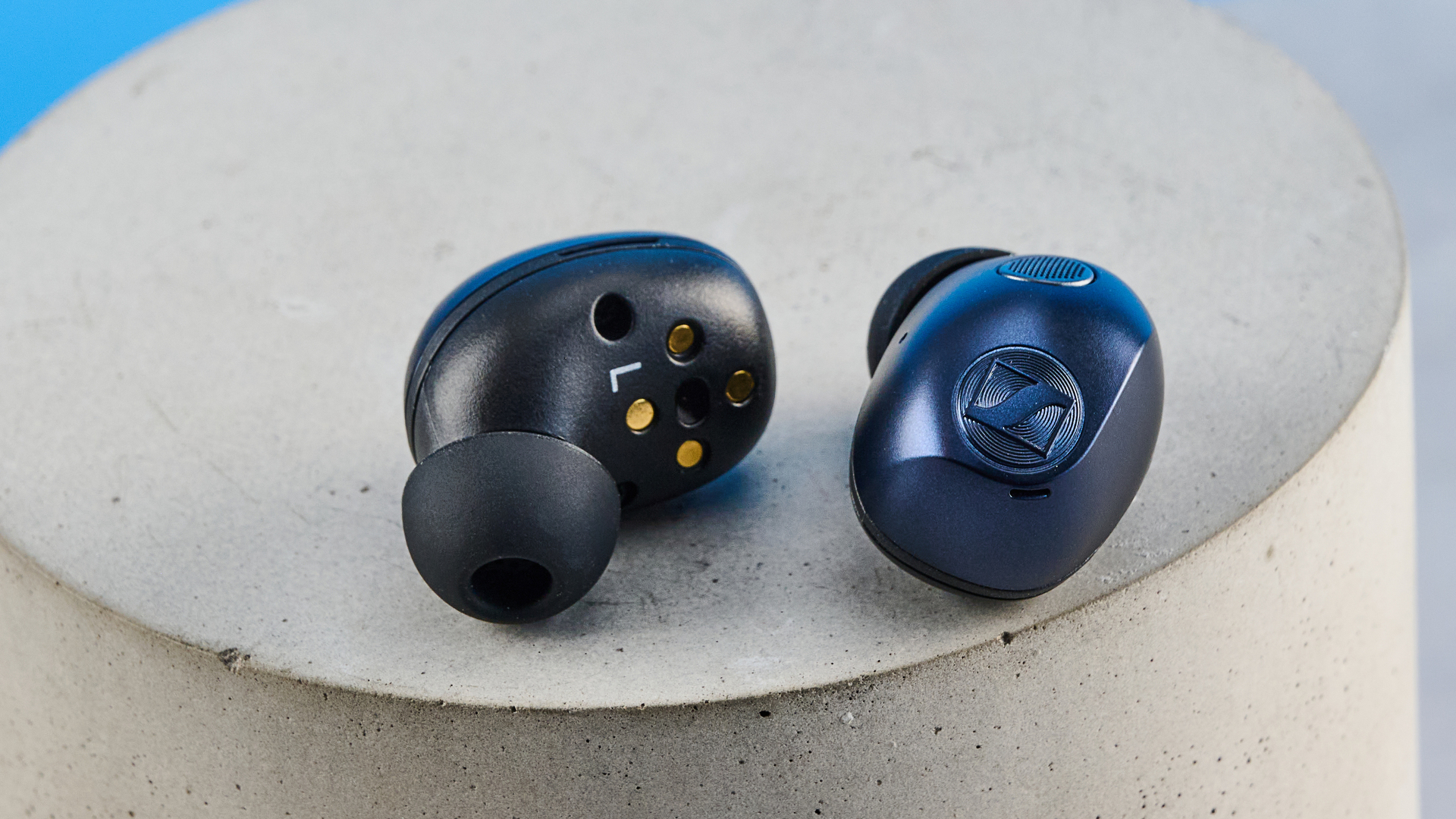 the sennheiser momentum 5 true wireless earbuds in navy photographed with the blue tom's guide background