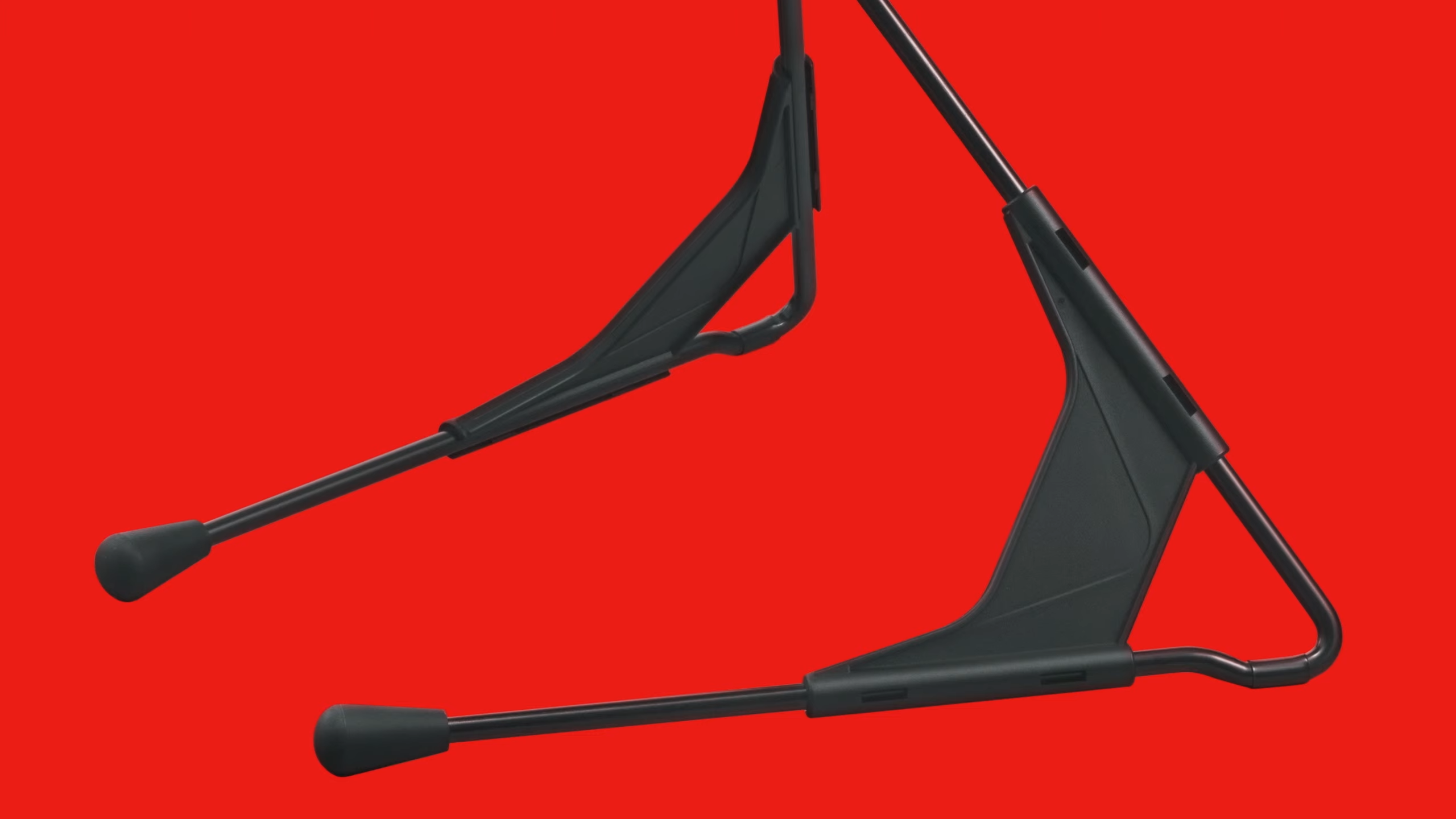 Close up of Virtual Boy tripod feet on red backdrop.