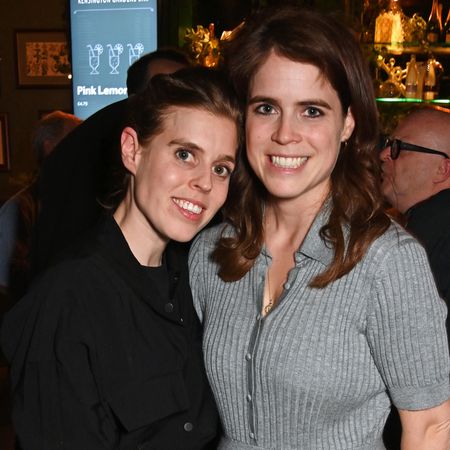 Princess Beatrice and Princess Eugenie smiling in a bar