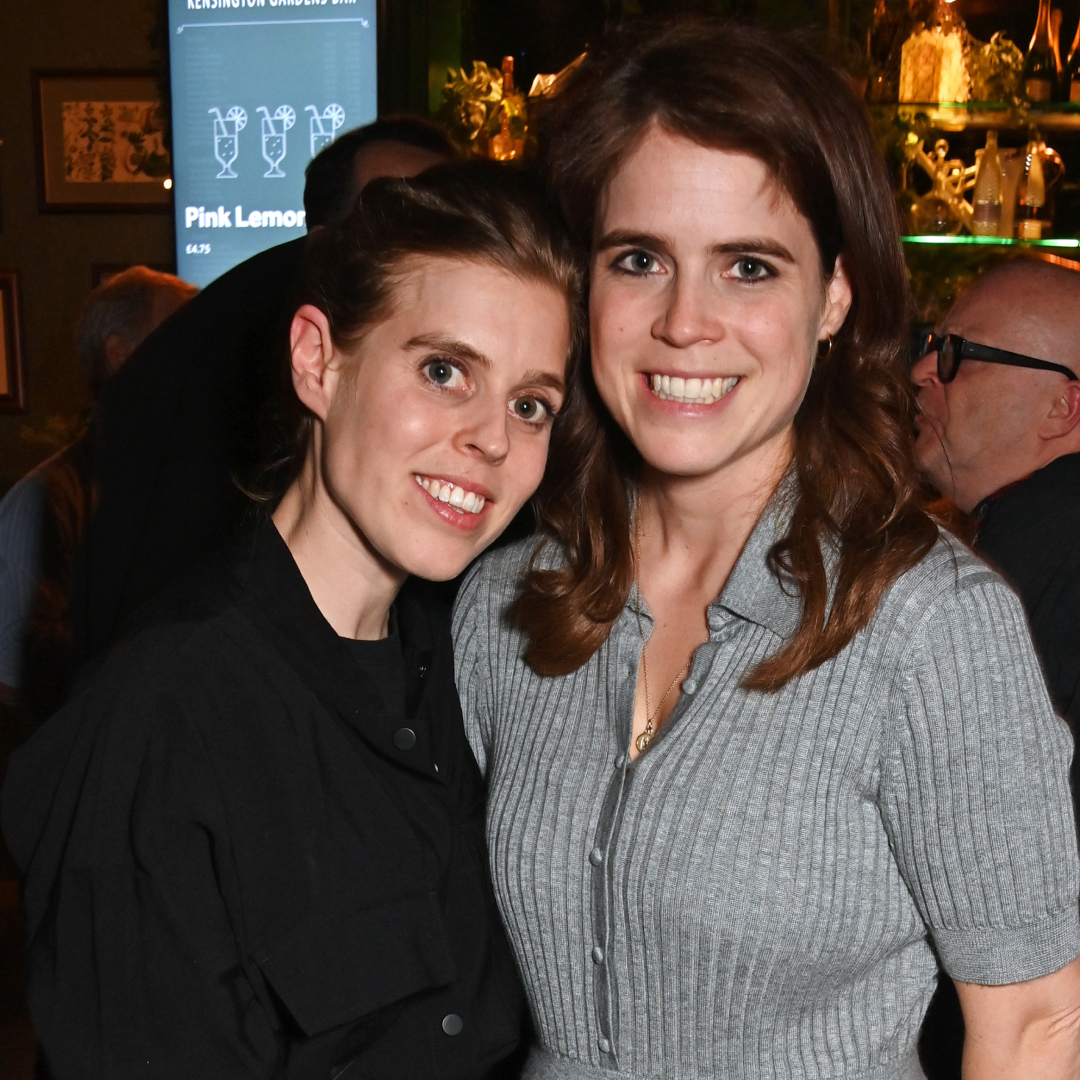 Princess Beatrice and Princess Eugenie smiling in a bar