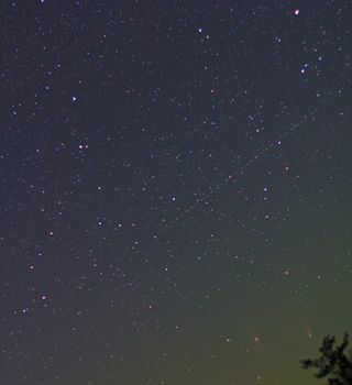 Comet Pan-STARRS in conjunction with the great Andromeda Galaxy, M31, on April 4, 2013, just over the treetops as an airplane enters the sky. A 50mm lens captured the two.