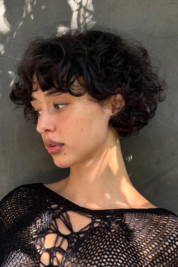 A model shows off their new curly bixie cut by Isabella Sementilli.