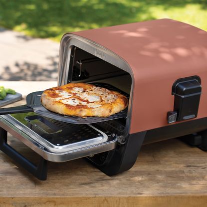Ninja Woodfire Electric Outdoor Oven on table outdoors