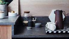 Kitchen countertop close up with coffee mugs, carafe and accessories