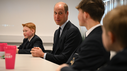 Britain's Prince William, Prince of Wales (C) speaks with students of the Matrix Project, including twelve-year-old Freddie Hadley (L), who made the initial invitation to visit the school