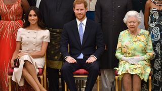 TOPSHOT - (L-R) Meghan, Duchess of Sussex, Britain's Prince Harry, Duke of Sussex and Britain's Queen Elizabeth II pose for a picture during the Queen's Young Leaders Awards Ceremony on June 26, 2018 at Buckingham Palace in London. (Photo by John Stillwell / POOL / AFP)