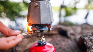 best camping stoves: a camping stove being lit