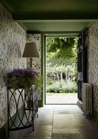 hallway with botanical wallpaper with flagstone floors