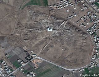 A satellite photo taken in 2016 that shows the ancient city of Mari in Syria. Notice that it is heavily scarred with looting pits.