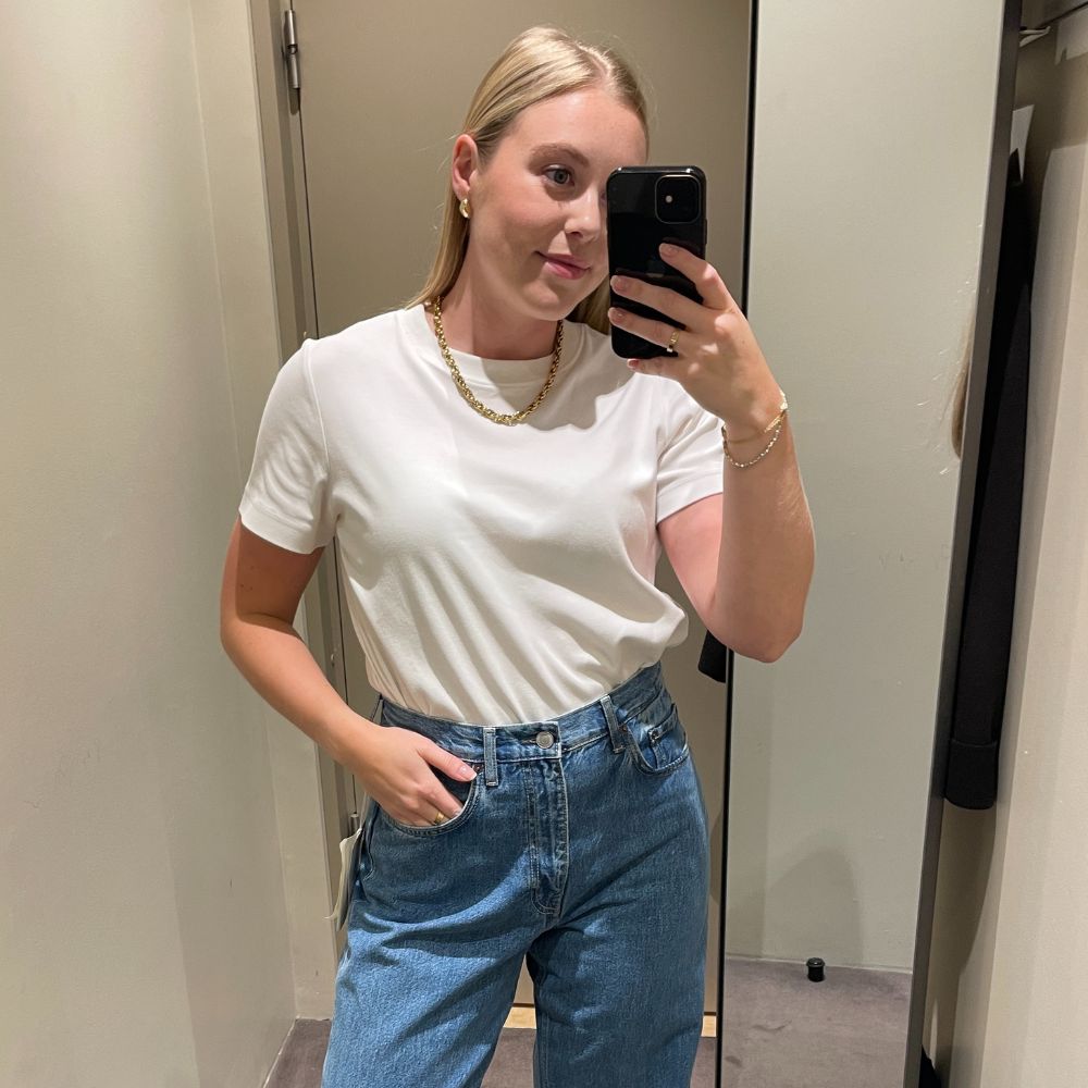 Woman wears white T-shirt and blue jeans 
