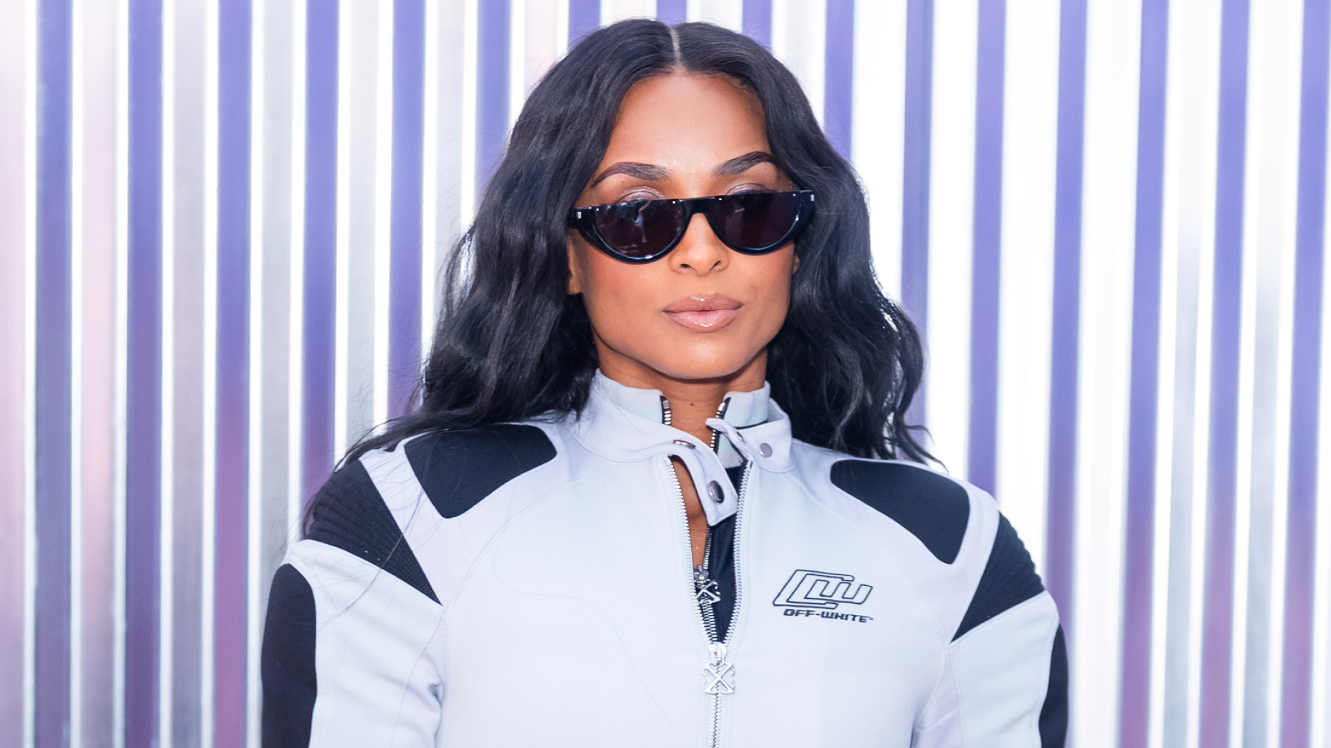 A woman with black hair wearing sunglasses and a jacket