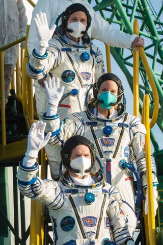 Expedition 64 Russian cosmonaut Sergey Kud-Sverchkov of Roscosmos, top, NASA astronaut Kate Rubins, middle, and Russian cosmonaut Sergey Ryzhikov, bottom, wave farewell prior to boarding the Soyuz MS-17 spacecraft for launch, Wednesday, Oct. 14, 2020, at the Baikonur Cosmodrome in Kazakhstan.