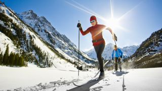 Two women cross country skiing in the backcountry on a sunny day