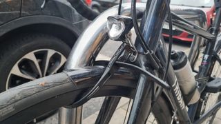 A Hiplok Z Lok Combo securing the front wheel of a road bike to a Sheffield stand