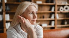 Close up portrait of mature woman looking sad with hands clasped