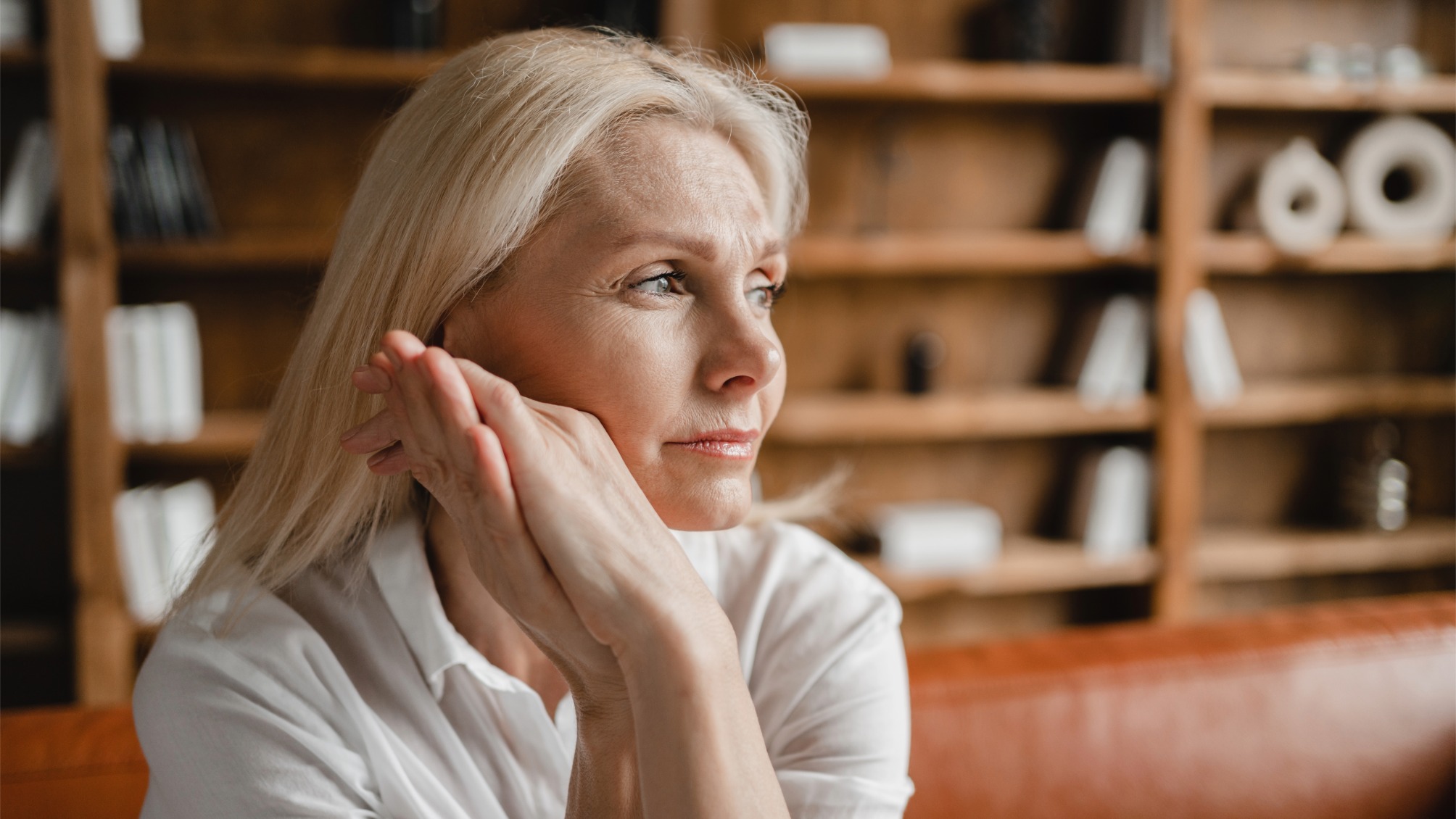 Close up portrait of mature woman looking sad with hands clasped