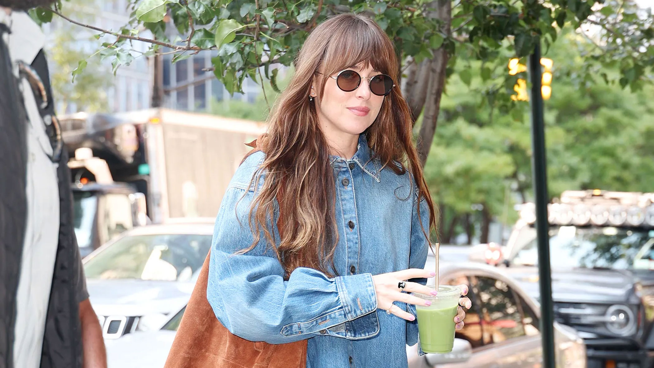 Dakota Johnson wears a brown suede shoulder bag