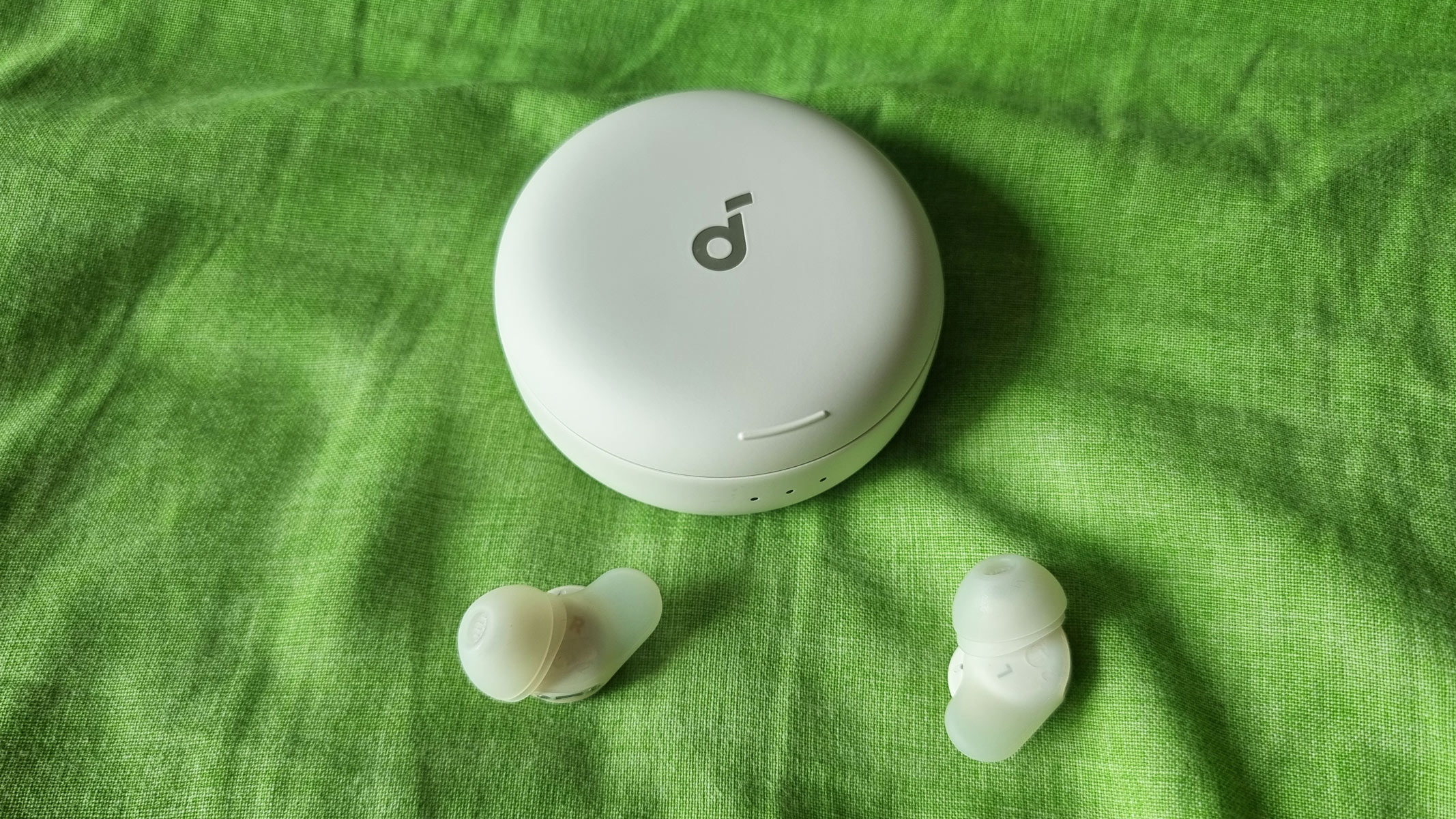 Soundcore Sleep A30 earbuds laid out next to a closed charging case