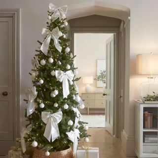 hallway with a fir christmas tree dressed in white satin bows