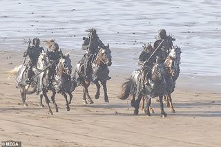 Actors portraying the Wild Hunt ride down a beach