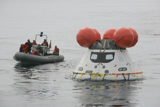 A U.S. Navy boat approaches NASA's Orion space capsule off the coast of San Diego, California, during Pacific Ocean recovery tests on Aug. 2, 2014.