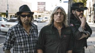 Motorhead posing for a photograph on a sidewalk