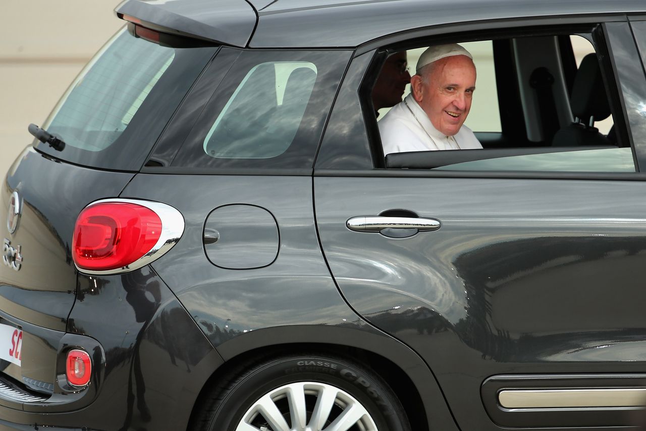 Pope Francis rides off in the back of a Fiat hatchback