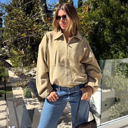 Sofia Richie Grainge wears an SRG Atelier suede bomber jacket, jeans and tan slingback heels.