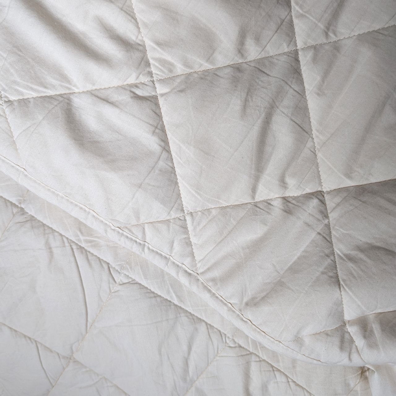 A close up of the diamond pattern on the woolroom mattress topper.