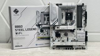 An ASRock B860 Steel Legend Wi-Fi motherboard on a desk with SSD covers removed.