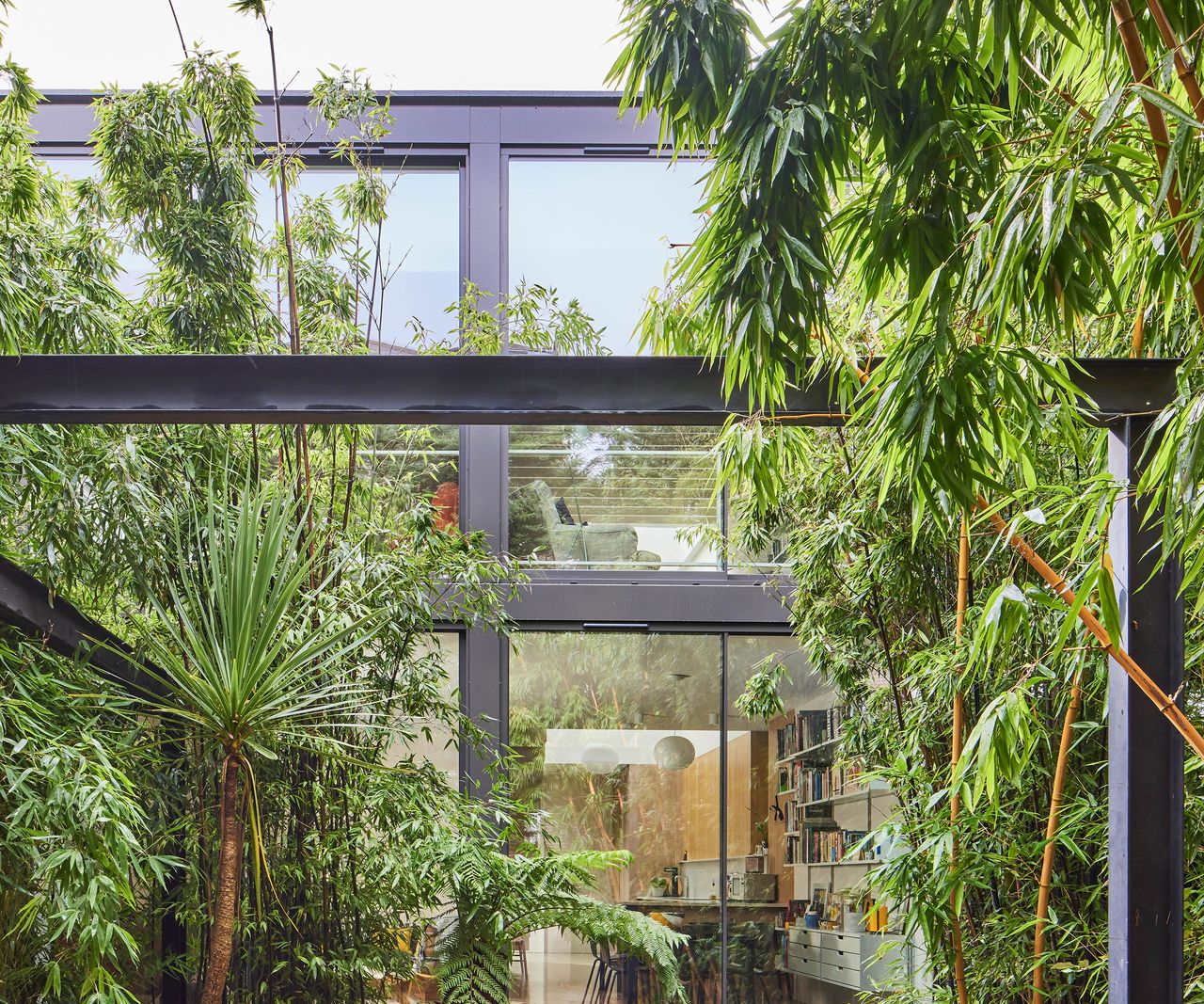 The rear exterior of a contemporary house extension with glazed floor-to-ceiling sliding doors and windows on both levels