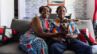 Couple sat on couch with their dog