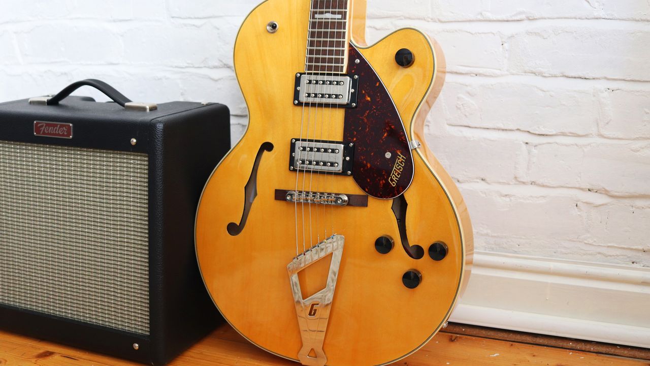 Gretsch G2420 against a white brick wall.