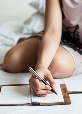 Woman writing in notepad