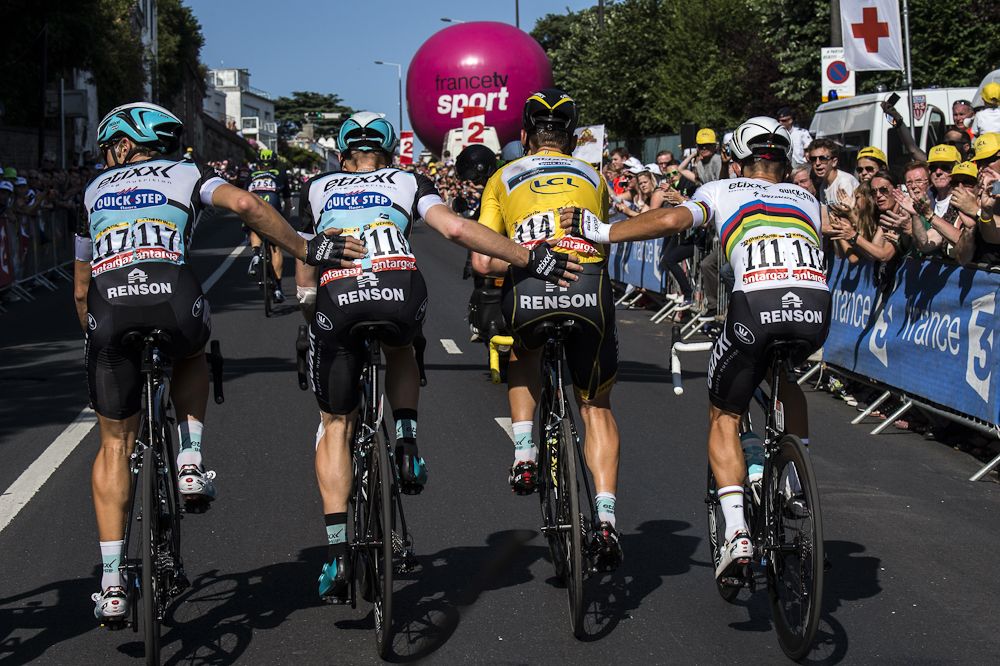Tony Martin's teammates push him to the line after he fractured his clavicle in a crash at the finish of stage 6.